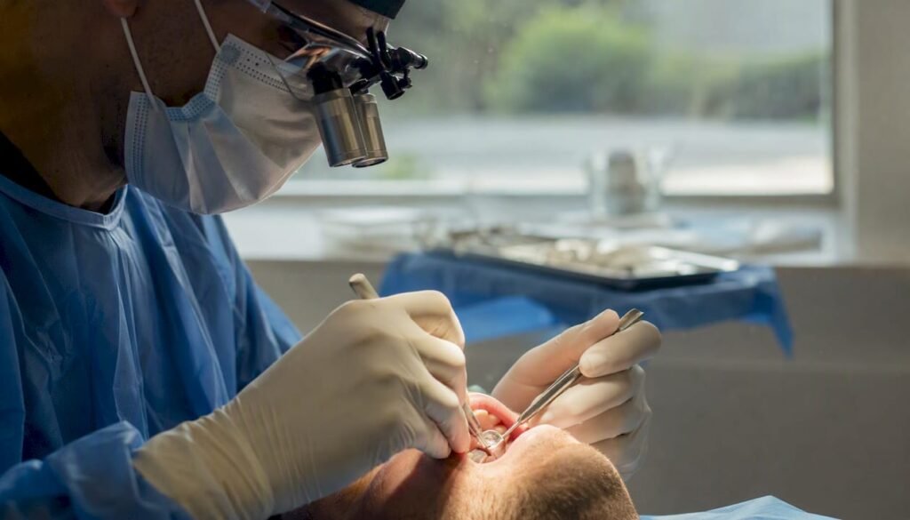Mani del dentista che eseguono un innalzamento del seno mascellare