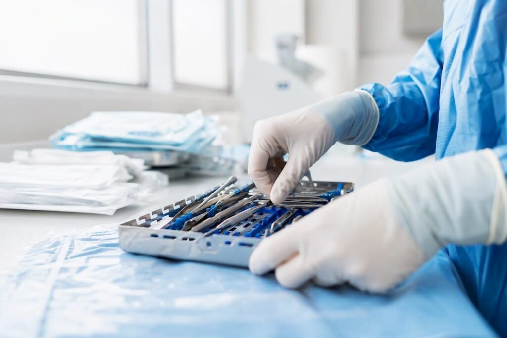 Mani guantate che maneggiano strumenti per impianti dentali